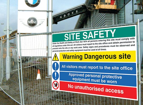 A BMW site has a safety sign hung on a fence