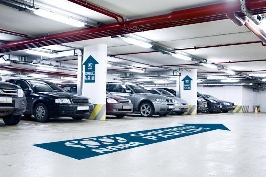 A parking garage has graphics on the cement to guide traffic