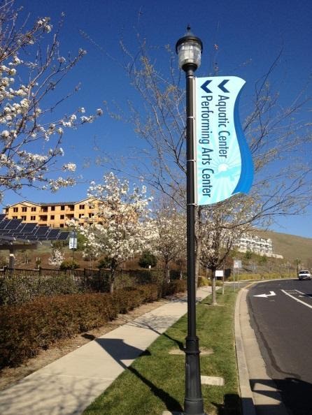 A sign is attached to a streetlight pole