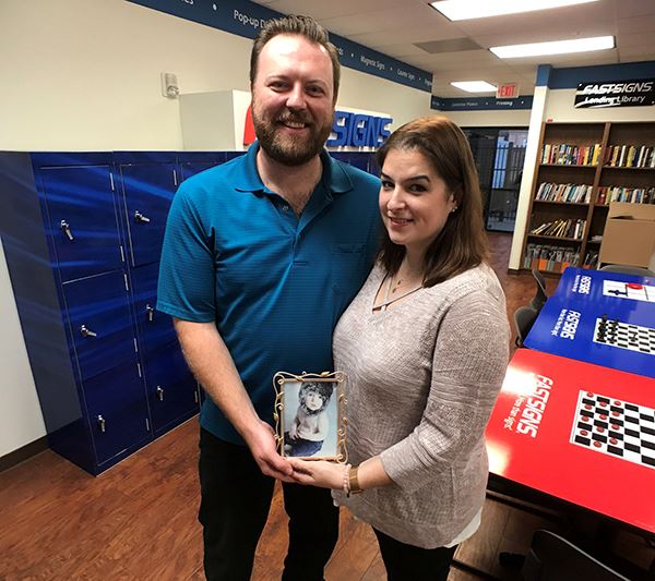 William and Jayme Nelson pose with an image of their child